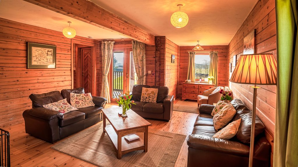 Self Catering Holiday Accommodation - Large lounge with wood burning stove, French windows opening out onto veranda. Free Wifi, television with FreeSat, DVD and hi-fi.